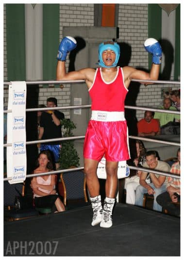Bokser juicht met beide handen omhoog in de ring