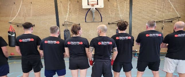 Leden van de club op een rij in clubshirts, van achteren gezien